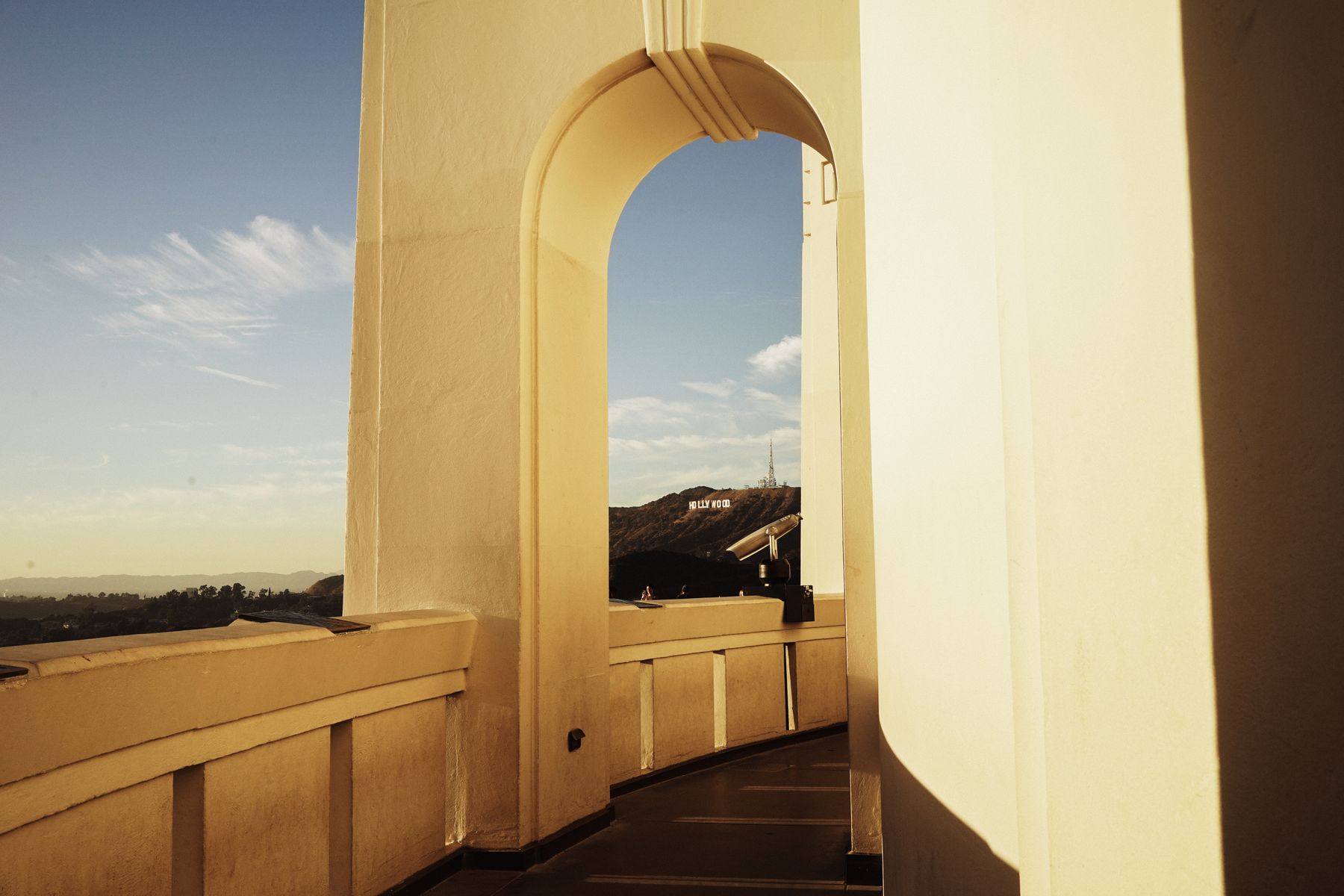 The Hollywood Sign framed by an arch at Griffith Observatory in Los Angeles