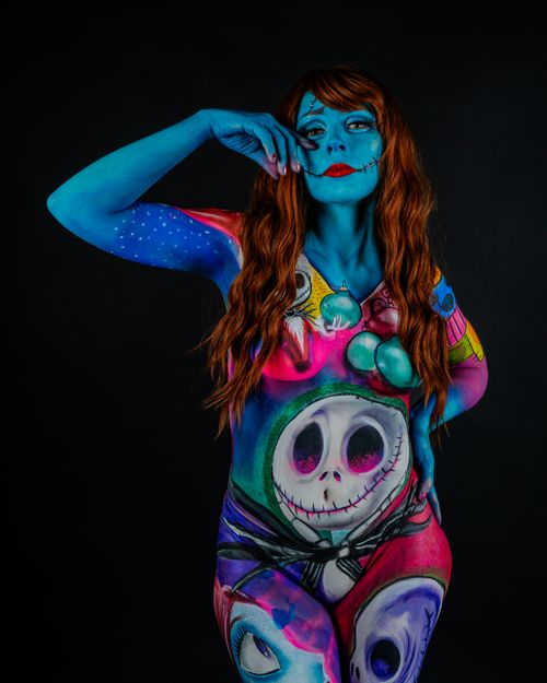 Free Colorful body paint featuring fantasy and horror elements with a model in vibrant makeup. Stock Photo