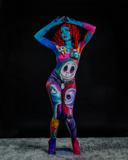 Free A woman with vibrant surreal body paint poses confidently, showcasing colorful artistic expression indoors. Stock Photo