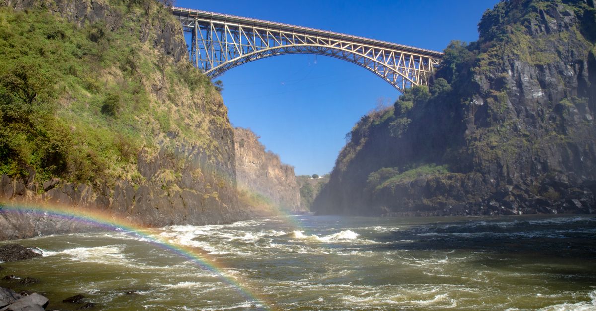 Viajero con el móvil frente a las cataratas Victoria usando una eSIM en Zambia