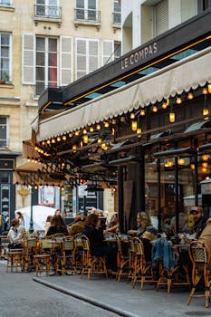 Cozy outdoor dining at a Parisian cafe with classic architecture and bustling ambiance.