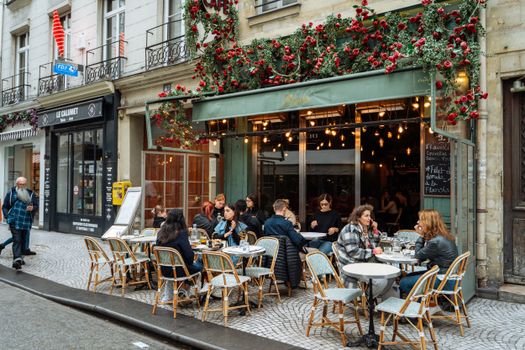Une scène de rue animée d'un café parisien avec une ambiance extérieure et une restauration dynamiques.