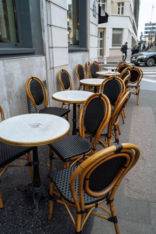 Free Charming outdoor seating at a Parisian café with classic wicker chairs and tables. Stock Photo