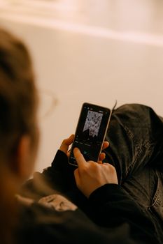 Close-up of a person editing a photo on a smartphone in a relaxed setting.