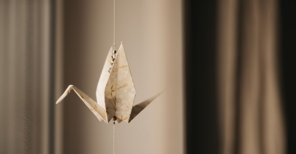 Elegant Origami Crane Hanging By A String Free Stock Photo elegant-origami-crane-hanging-by-a-string-free-stock-photo