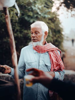 Portrait of an elderly man with a checkered scarf, depicting traditional street life in Keonjhar, India.
