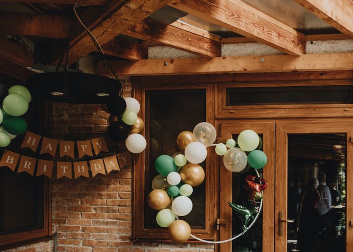 Birthday party with green, gold and white balloons