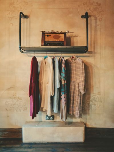Second-hand dresses hanging on a rustic wall-mounted rail, photo by Soner Arkan on Pexels