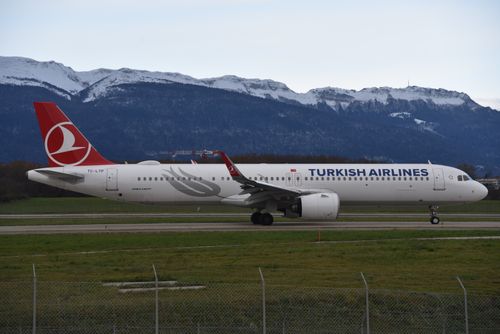 Free Turkish Airlines aircraft taxiing at Geneva Airport with snowy mountains in the background. Stock Photo