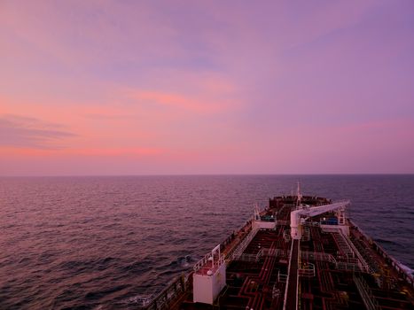 Stunning sunset view across the open sea from the deck of a cargo ship.