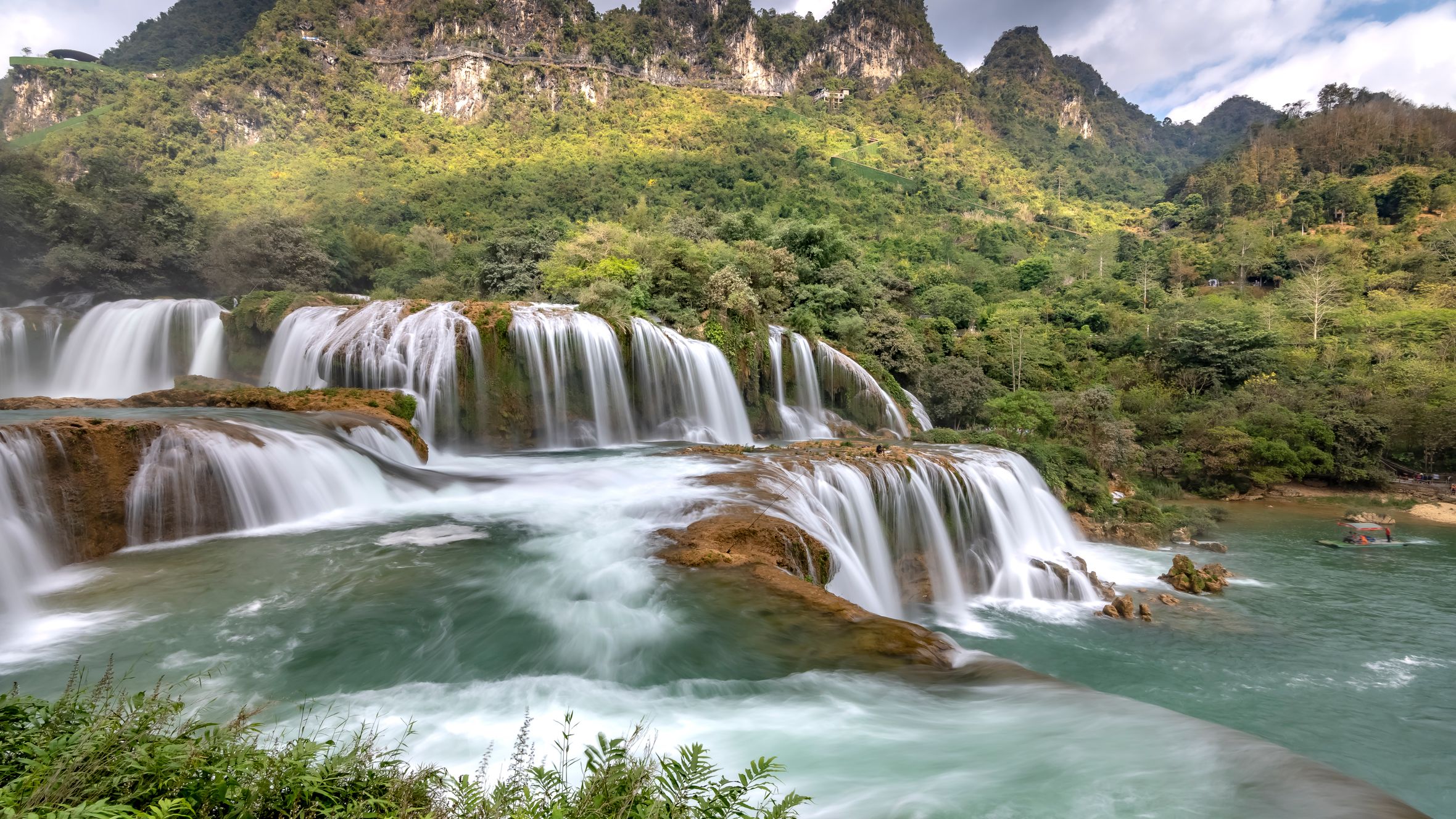 Scenic waterfall cascading in a vibrant green mountain landscape, perfect for nature lovers.