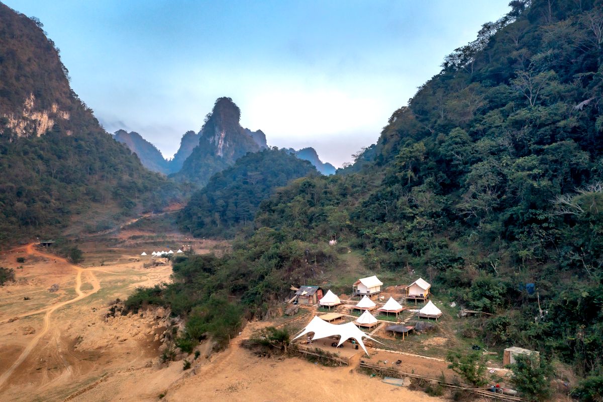 Veduta aerea di tende glamping in una valle verde di montagna