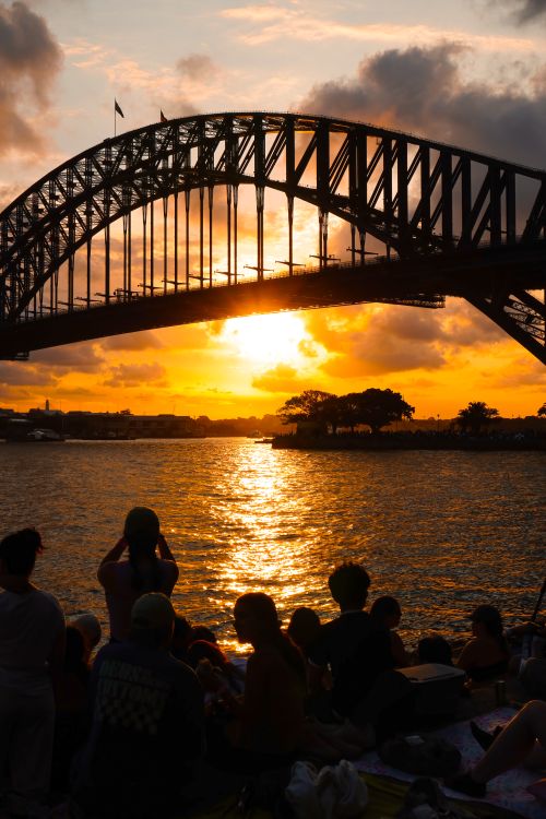 Free A beautiful sunset at Sydney Harbour Bridge with a silhouetted crowd enjoying the view. Stock Photo