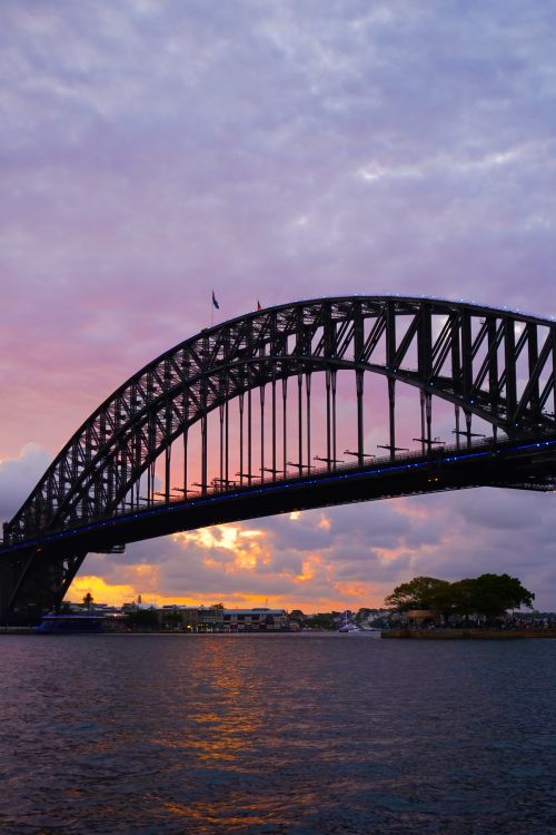 Free Iconic Sydney Harbour Bridge during a vibrant sunset, capturing urban architecture. Stock Photo