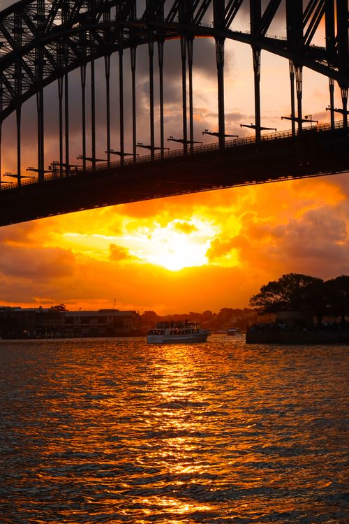 Free Stunning sunset view with vibrant orange skies and Sydney Harbour Bridge silhouette. Stock Photo