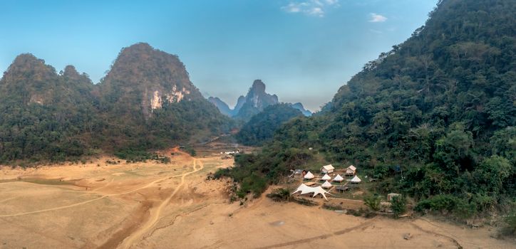 Aerial view of a scenic mountain valley with rustic camp tents. Ideal for nature and travel imagery.