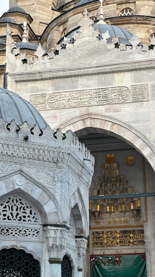 Free Detailed view of ornate Ottoman-style mosque entrance with inscriptions and domes. Stock Photo