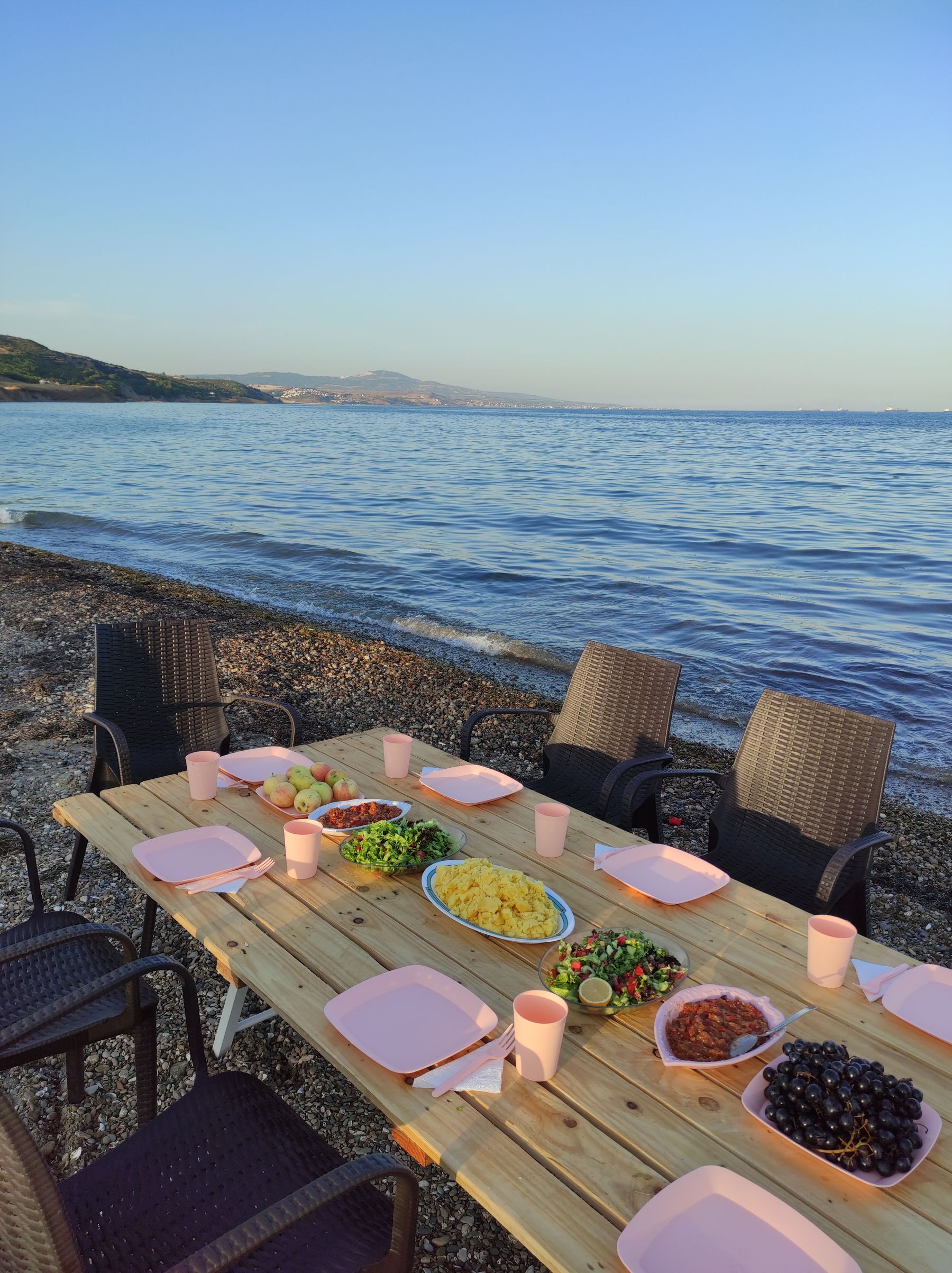 Sunset dining setting with the water visible beyond the table