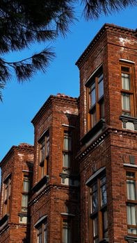 A detailed view of historic brick buildings with vibrant blue sky in the background.