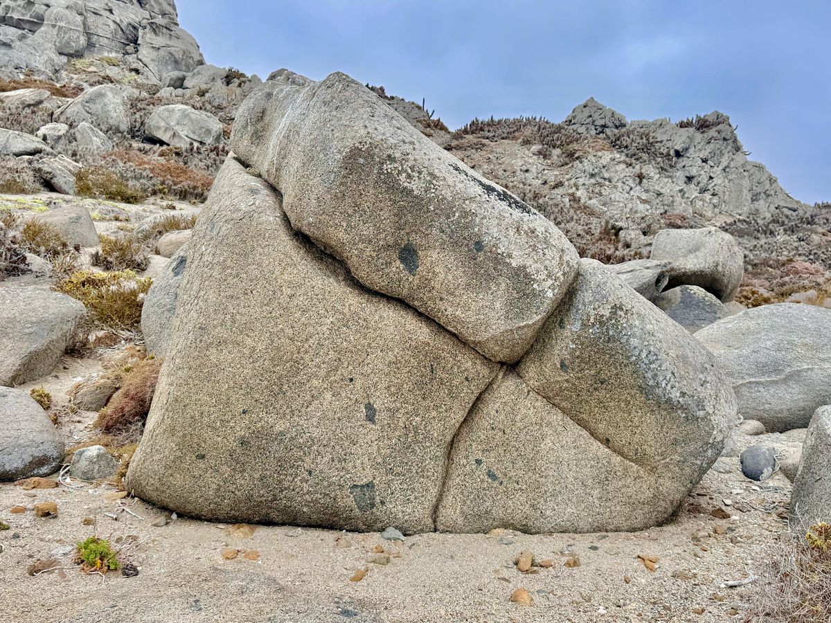 A large granite boulder in a rocky landscape