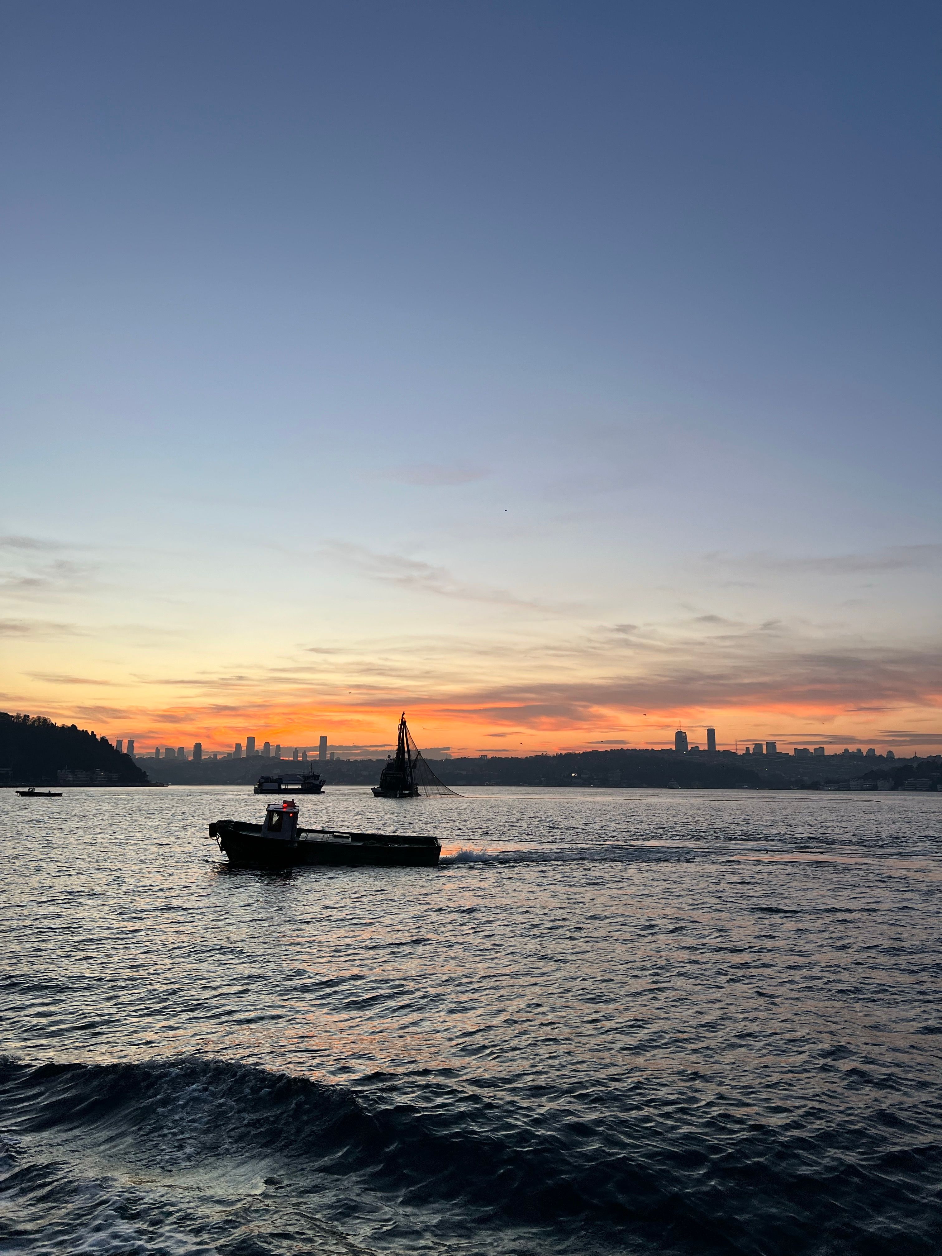 Sunset Silhouette of Boats on Calm Waters · Free Stock Photo