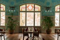 A beautifully designed Art Nouveau interior of a restaurant featuring stained glass windows and elegant decor.