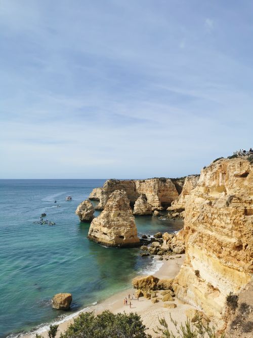 Free Breathtaking view of Algarve's rocky cliffs and clear blue waters under a sunny sky. Stock Photo
