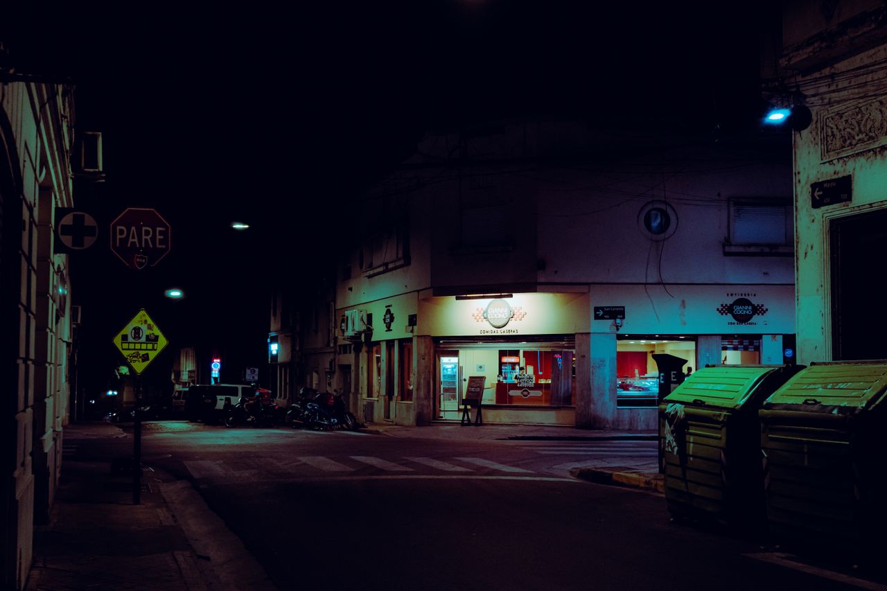 moody night scene of a street in rosario argentina with neon lights