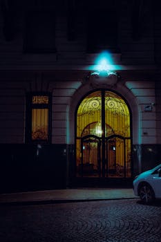 A moody, atmospheric night shot of a street in Rosario, showcasing illuminated architecture.