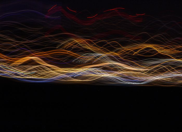 Warm light streaks across a black field — artwork by Yakup Gokdeniz on Pexels