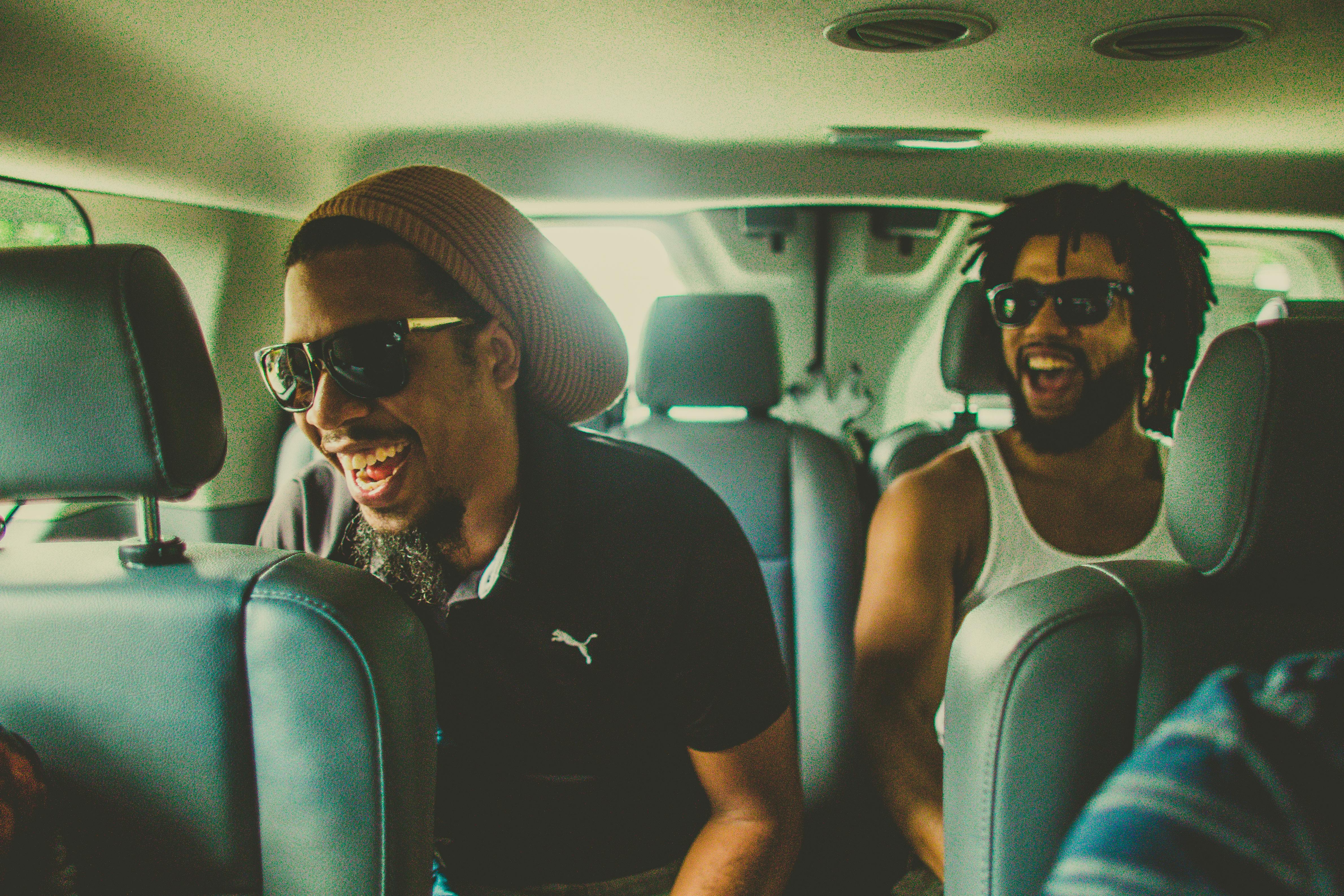 两个朋友在圣胡安骑行，在车里笑着玩耍，捕捉到了热闹的时刻