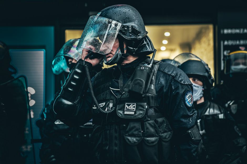 Police officers in tactical gear communicating during an operation in Paris.