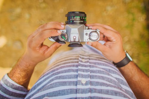 De Cima, Foto De Homem Segurando Uma Câmera Canon