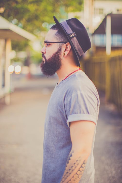 Vista Lateral De Un Hombre Con Camiseta Gris Con Cuello Redondo Y Sombrero Fedora Negro