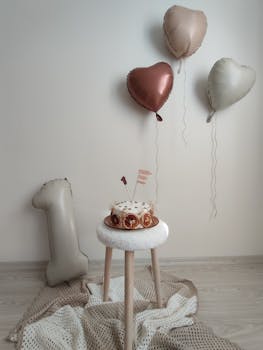 Heart-shaped balloons and cake for a stylish first birthday celebration.