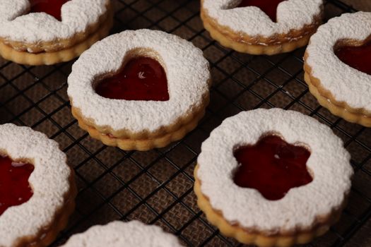 Heart-shaped Linzer cookies with raspberry jam, perfect for holidays or special occasions.