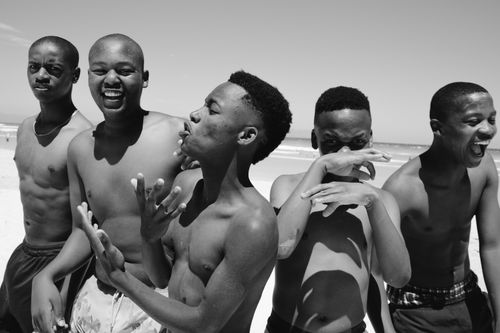 Free Five friends having fun on a sunny day at the beach, captured in black and white. Stock Photo