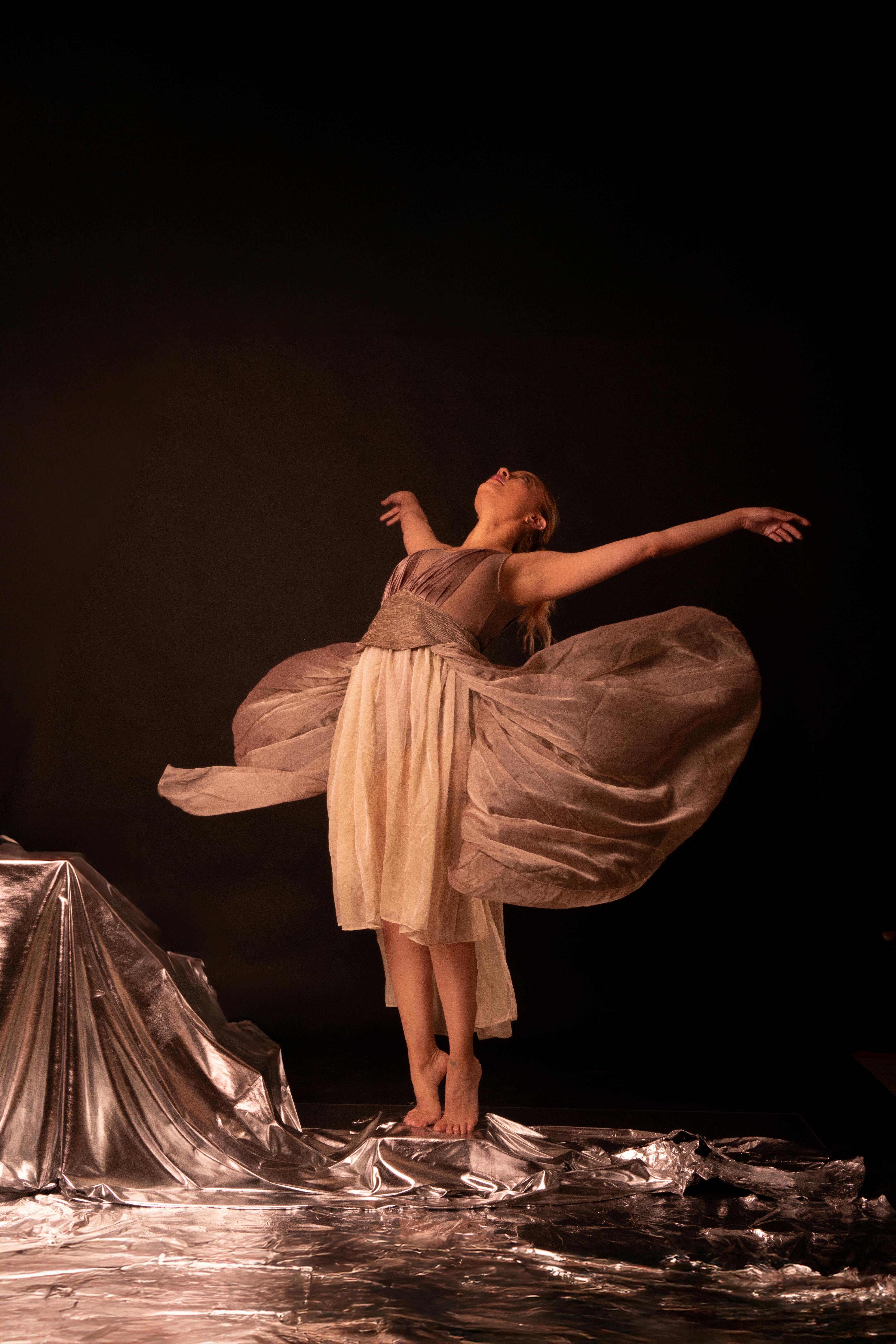 Kostenlos Künstlerisches Porträt einer Ballerina, die vor einem metallischen Hintergrund tanzt und anmutige Bewegungen zeigt. Stock-Foto