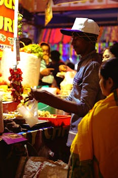People engaging at a lively Indian street food market at night.