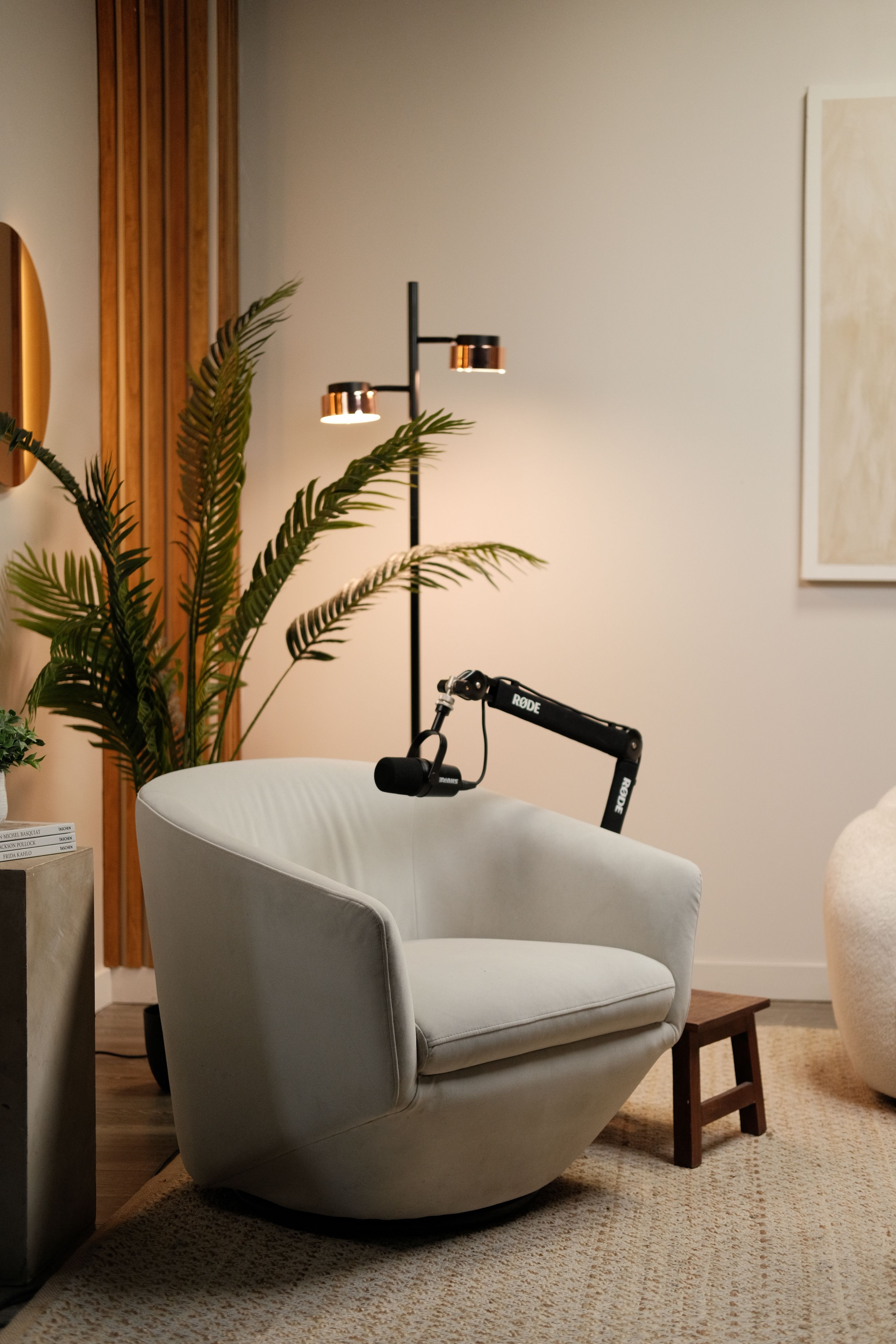 Close view of a microphone on a boom arm above a cream armchair