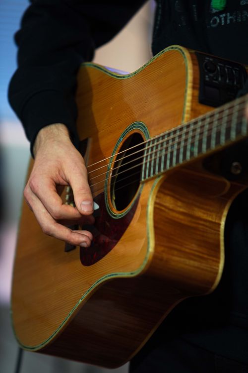 Free Detailed shot of a person strumming an acoustic guitar, showcasing finger technique. Stock Photo