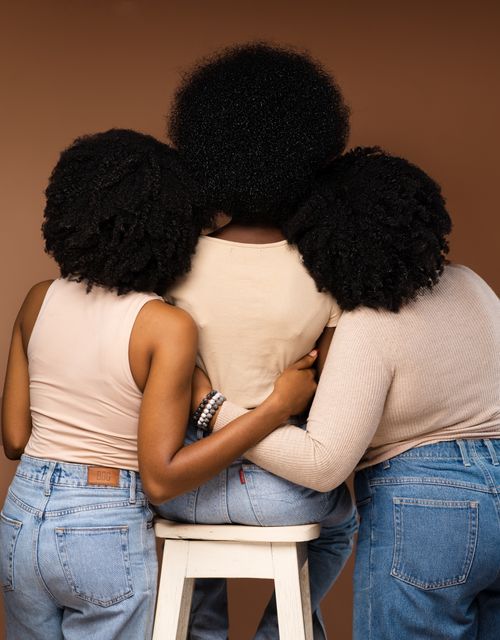 Free Three women with natural hairstyles embracing each other, showcasing unity and friendship. Stock Photo