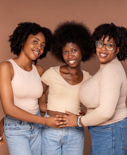 Free Three women with natural curly hair smiling and posing in casual outfits, showcasing friendship and joy. Stock Photo