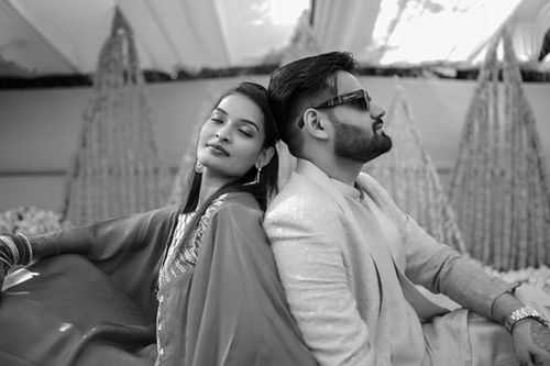 Free Elegant black and white portrait of a couple in stylish attire at a decorated event. Stock Photo