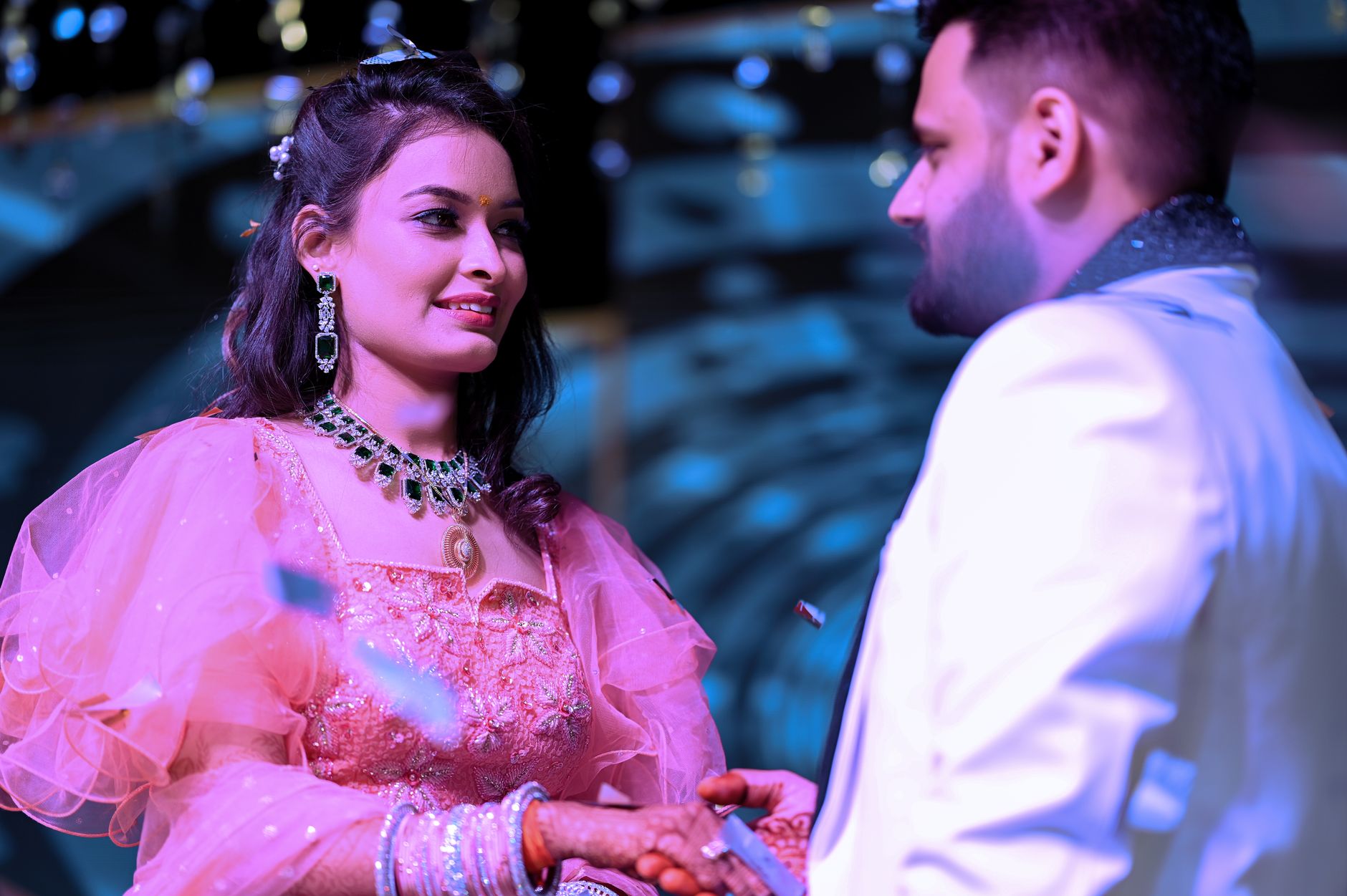 A joyful couple exchanging rings during their engagement ceremony, showcasing love and happiness.