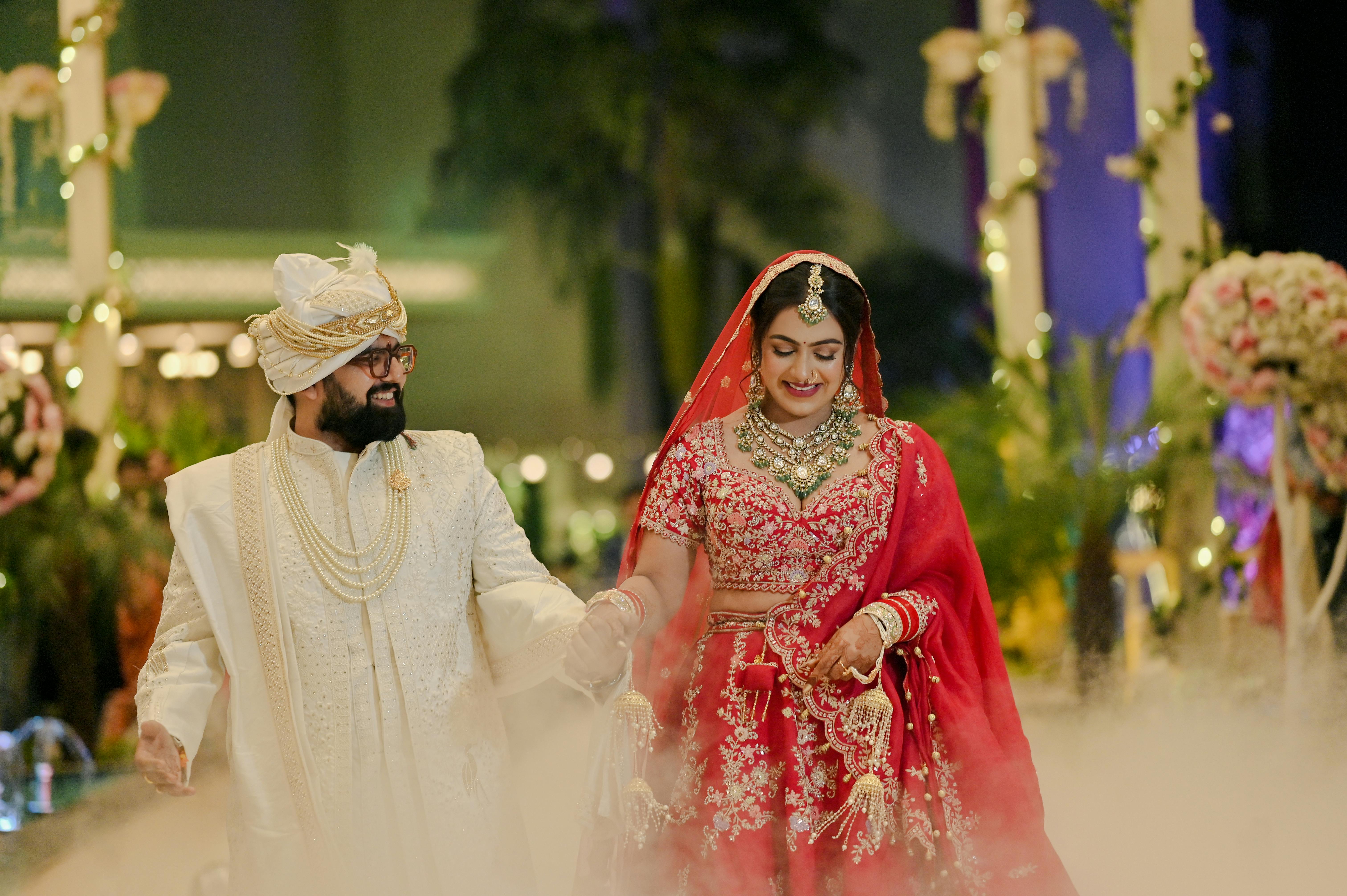 A joyful Indian couple in stunning traditional wedding attire celebrating their marriage.