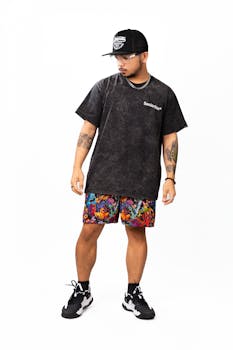 Male model posing in stylish black t-shirt and vibrant shorts.