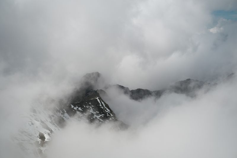 a snow ridge breaking through cloud — photograph by Alina Chernii on Pexels
