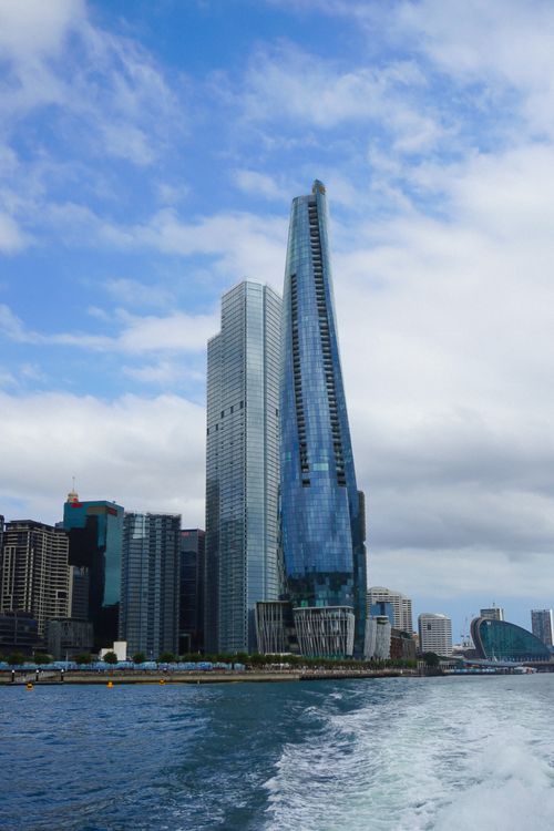 Free Sleek skyscrapers line the waterfront under a cloudy sky, reflecting modern architecture. Stock Photo