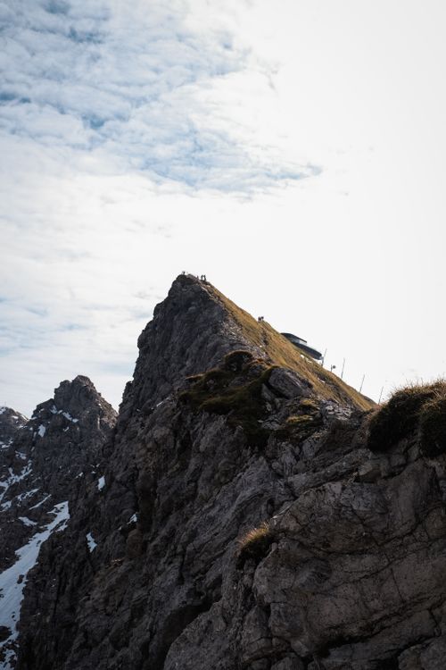 Free A dramatic view of a rugged alpine mountain peak with a cloudy sky backdrop. Stock Photo